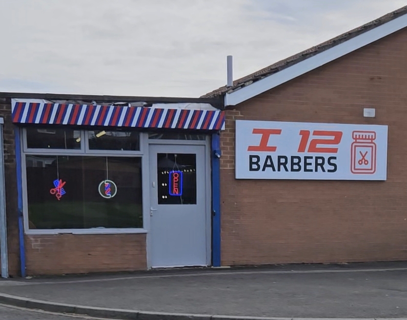 The i12 Barbers shopfront on Warkworth Drive, with its striped awning and orange sign
